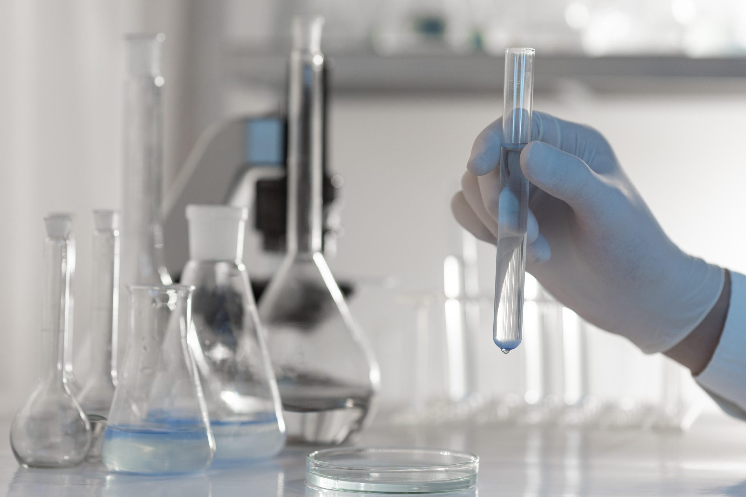 A close up hand holding tube with solution