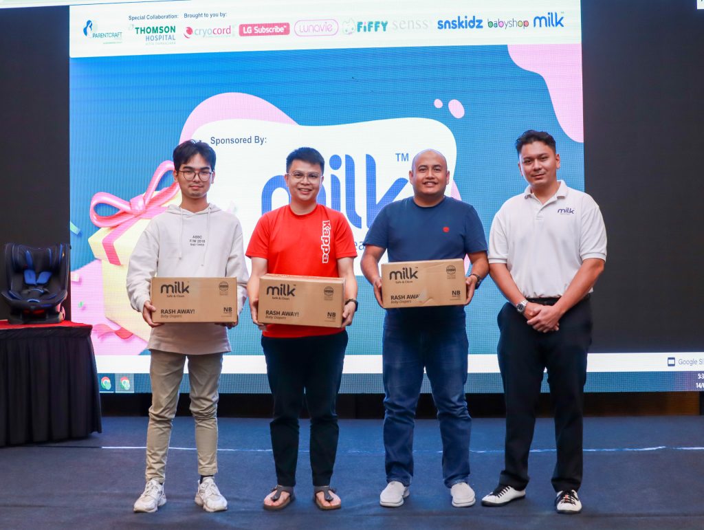 3 winners holding a box of diapers