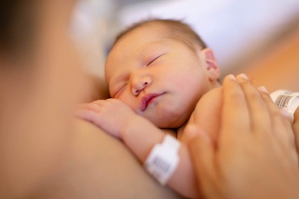 newborn baby cuddling with mother