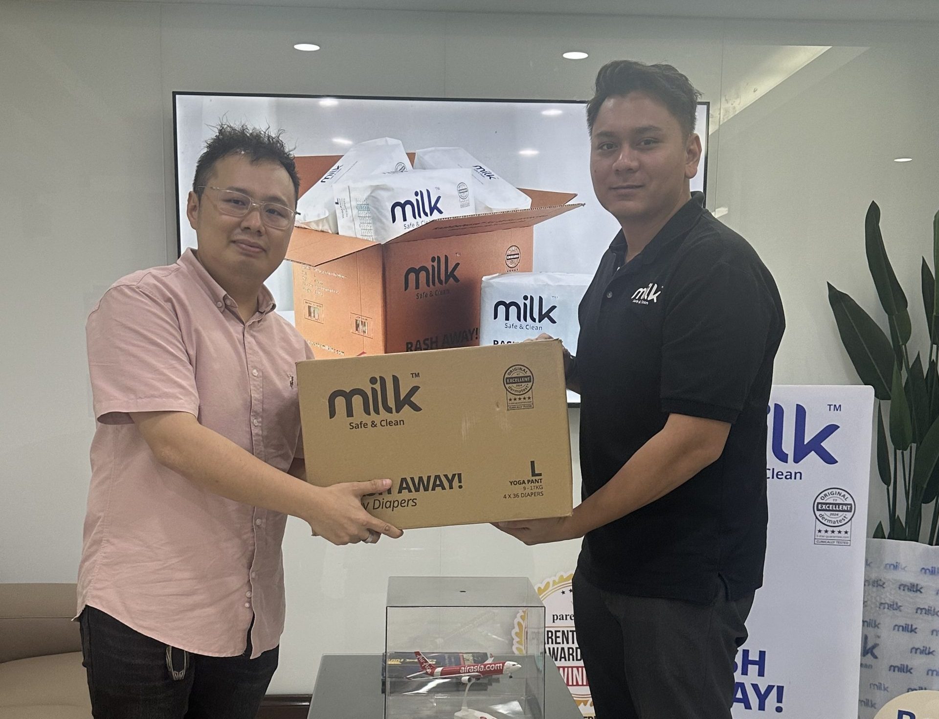 Man holding MILK boxes with customer